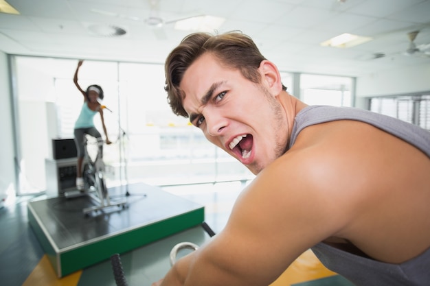 Handsome man smiling at camera in spin class