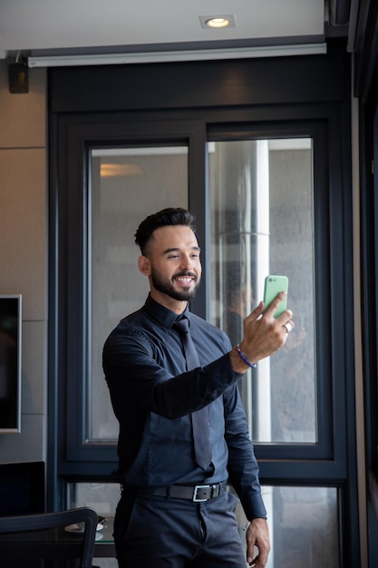 handsome man smiling at cell phone, man wearing beard and handsome smile answering a video call, han