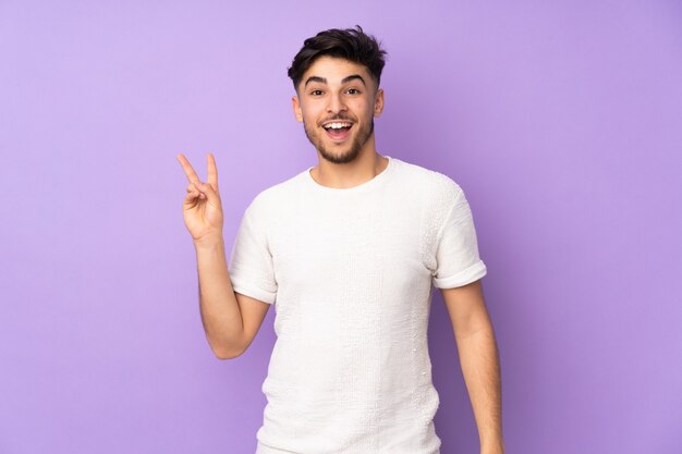 handsome man smiling and showing victory sign