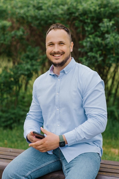 Handsome man smiling with mobile phone outdoors