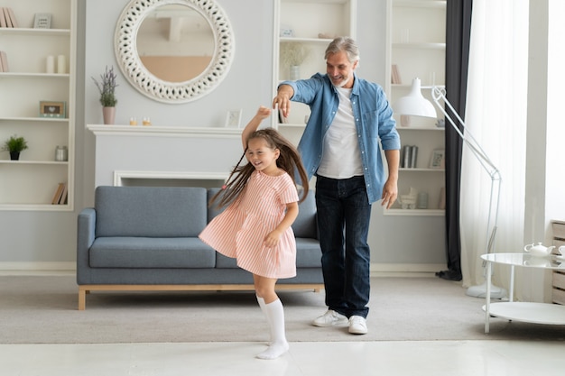 Handsome man spending time at home with his cute little daughter. Happy Father's Day! Dad and daughter.