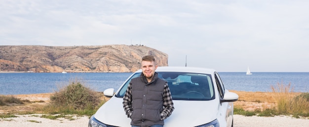 Handsome man standing in front of white car