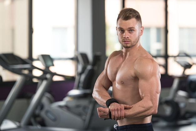 Handsome Man Standing Strong In A Modern Gym And Flexing Muscles  Muscular Athletic Bodybuilder Fitness Model Posing After Exercises