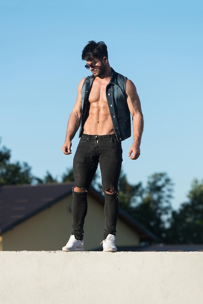 Handsome Man Standing Strong and Posing at Outdoors Wearing Black Jeans  Background of Sky