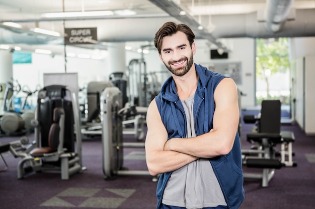 Handsome man standing with arms crossed in the gym