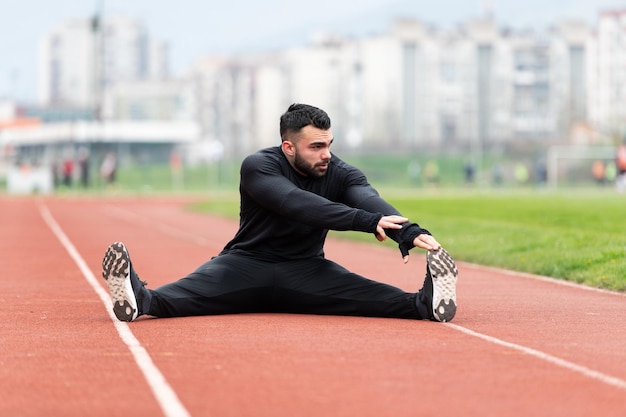 ランニングの外で運動する前にストレッチするハンサムな男