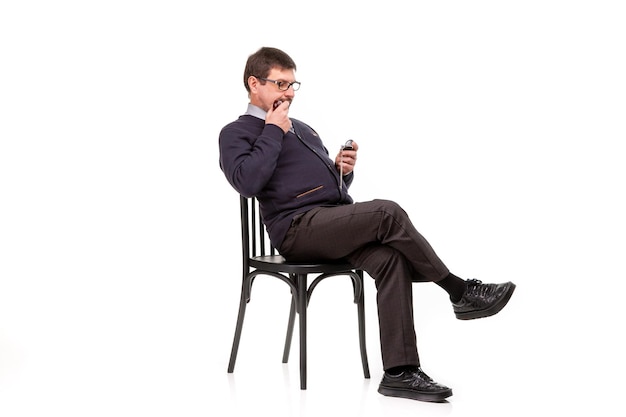 A handsome man in a suit and glasses sits with a pipe for smoking White background