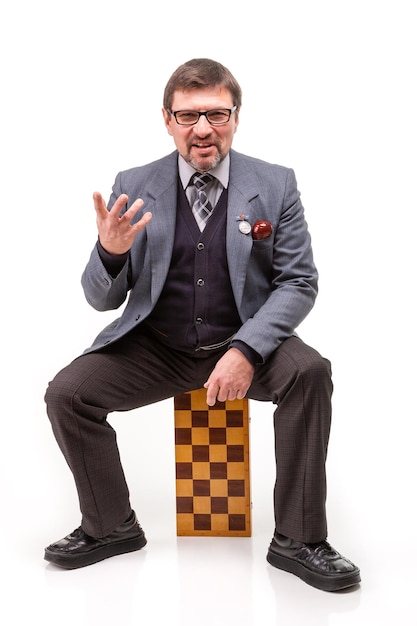 A handsome man in a suit and glasses with chess and a pipe for smoking White background