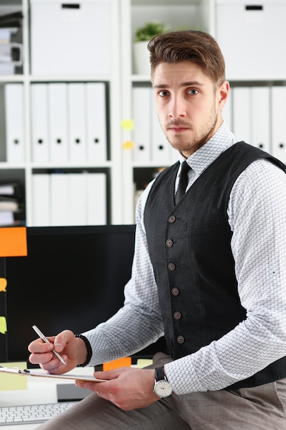 Photo handsome man in suit hold in arms silver pen and pad