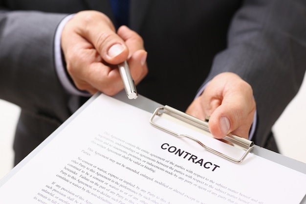 Handsome man in suit offer contract form on clipboard pad