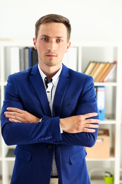 Uomo bello nel supporto del vestito in ufficio