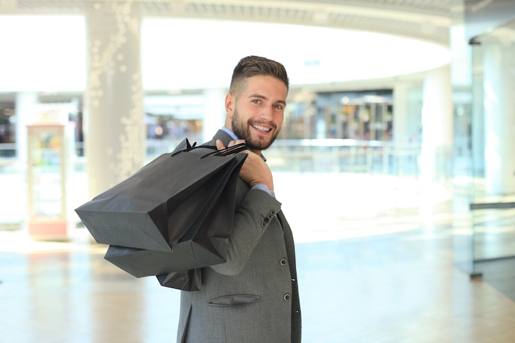 Photo handsome man in suit with shopping bags.