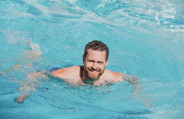 Красивый мужчина в бассейне у бассейна концепция летнего курортного отдыха