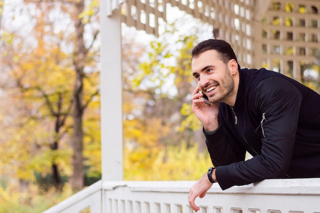 Bell'uomo parlando al telefono nel parco della città