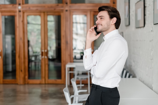 Handsome man talking on the phone in the office