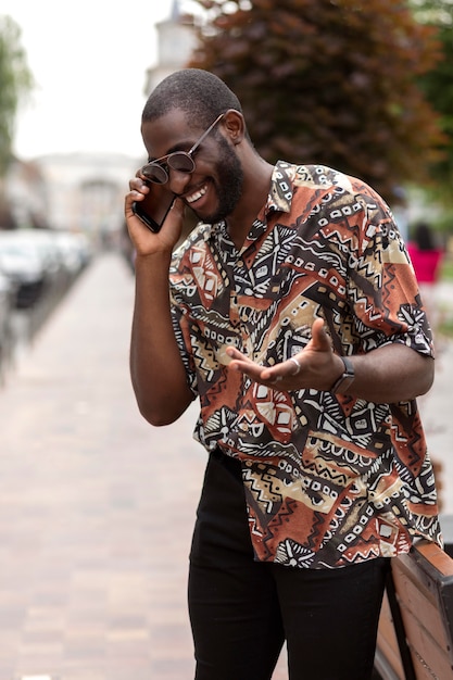 Photo handsome man talking on the phone outdoors