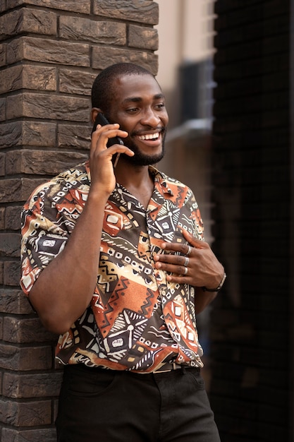 Photo handsome man talking on the phone outdoors