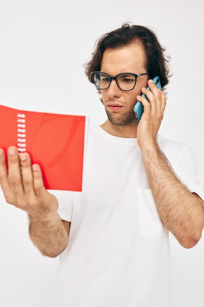 Красивый мужчина разговаривает по телефону красный блокнот изолированный фон