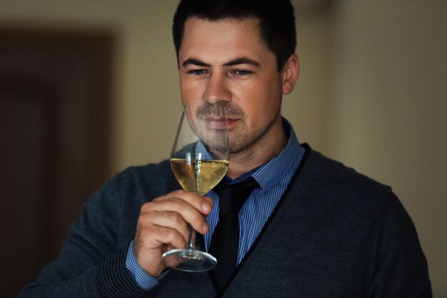 Handsome man tasting white wine