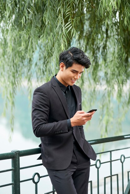 Handsome man texting with phone