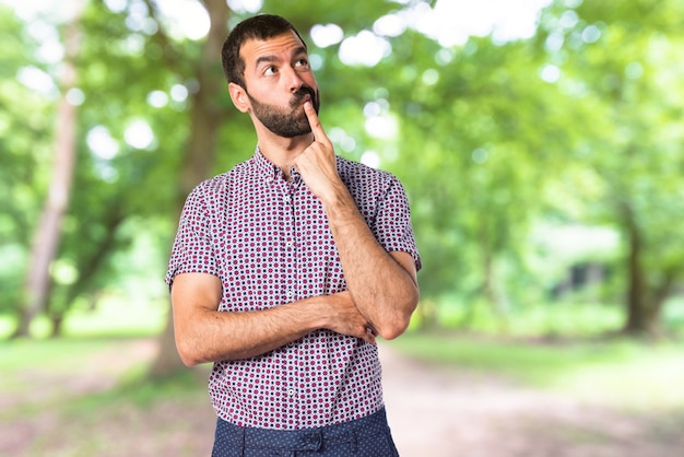 Handsome man thinking on unfocused background