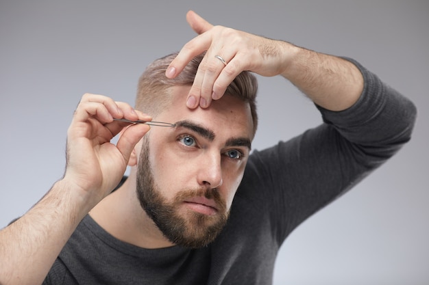 Handsome Man Tweezing Eyebrows