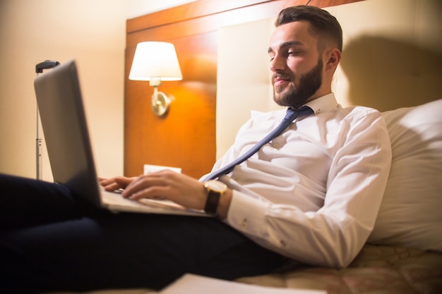 Handsome Man Using Laptop in Bed