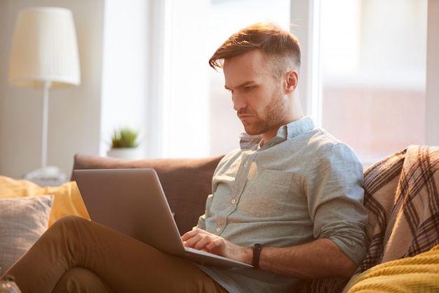 Handsome Man Using Laptop at Home