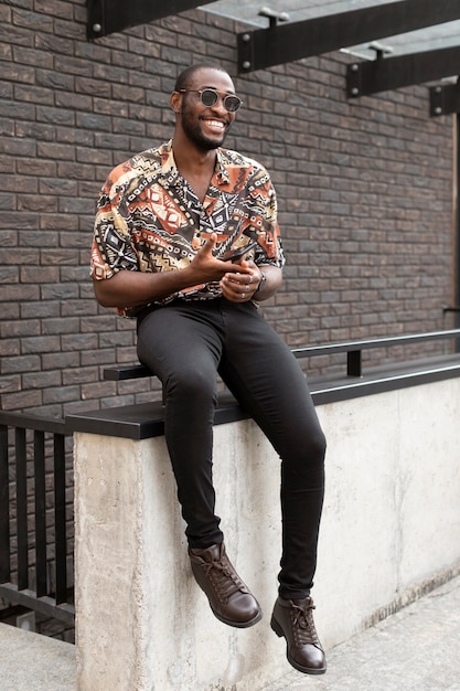 Photo handsome man using modern smartphone outdoors