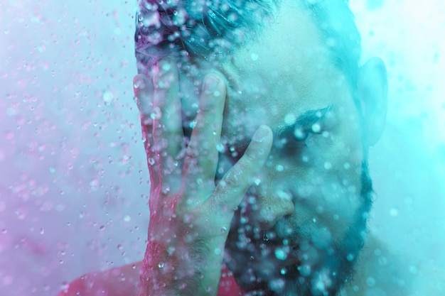 Handsome man under water flow