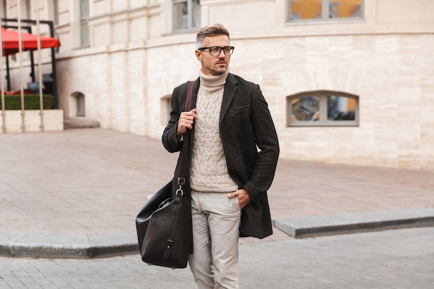 Handsome man wearing a coat walking outdoors