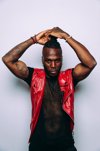 Handsome man wearing red leather jacket portrait. Futuristic cyberpunk fashion style. Studio light shot on white background