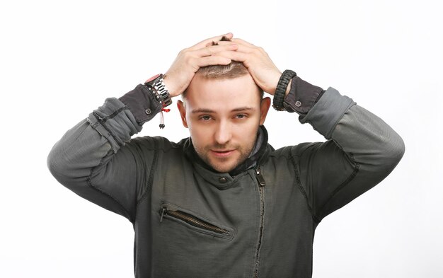 Handsome man on a white background holding his hands behind his head