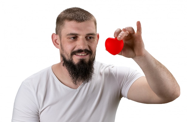 Foto uomo bello nella maglietta bianca che tiene cuore rosso in sue mani con lo spazio della copia. concetto di san valentino