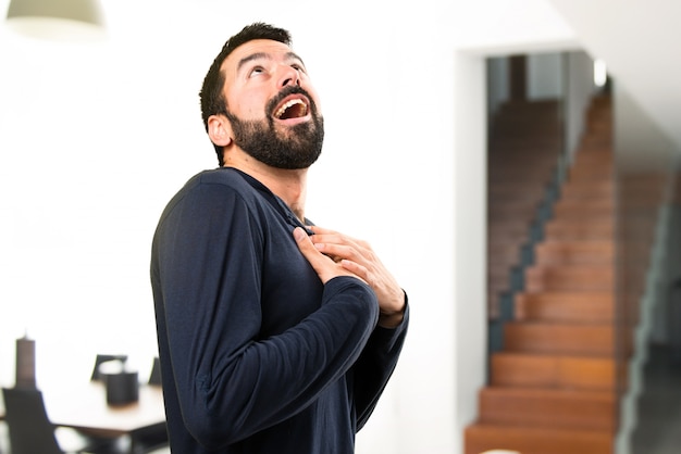 Handsome man with beard looking up inside house