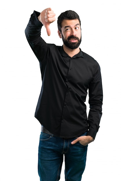 Handsome man with beard making bad signal on white background