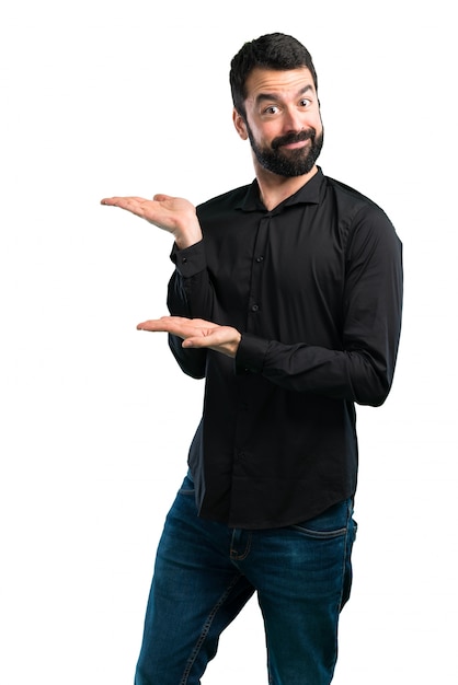 Handsome man with beard presenting something on white background