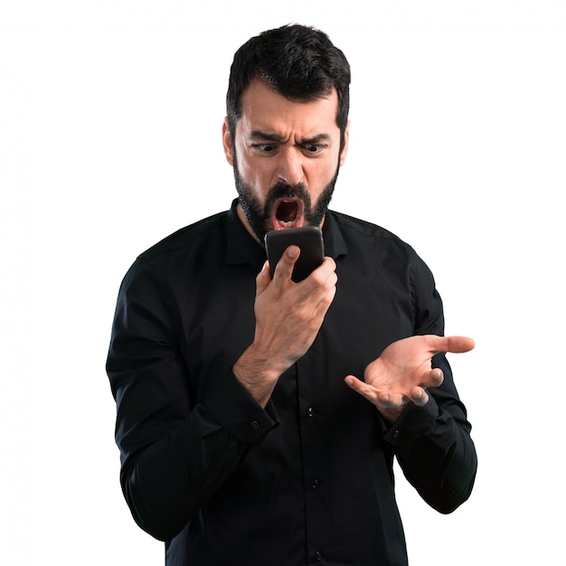 Handsome man with beard talking to mobile on white background