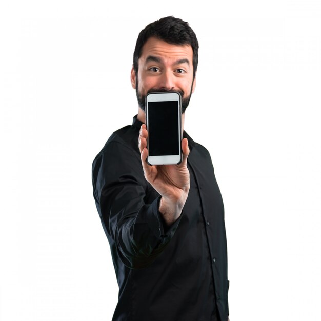 Uomo bello con la barba che parla con cellulare su fondo bianco