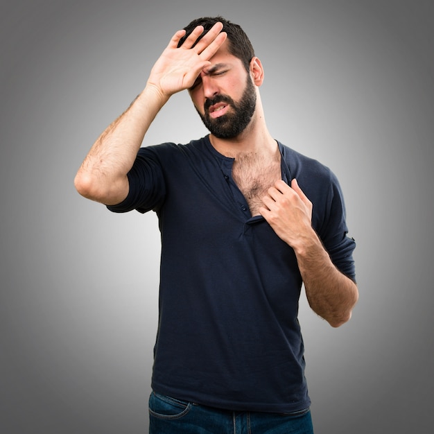 Uomo bello con la barba con la febbre su sfondo grigio