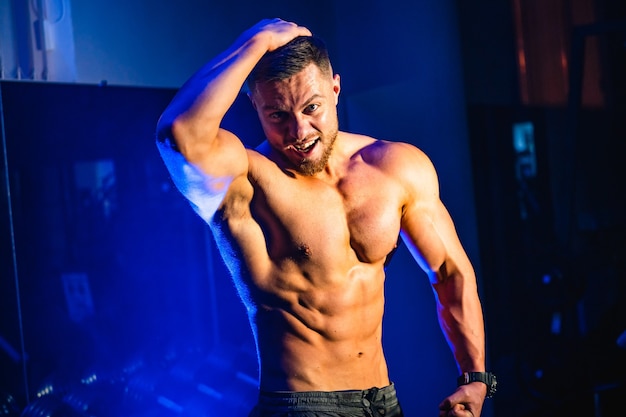 Handsome man with big muscles, posing  in the gym