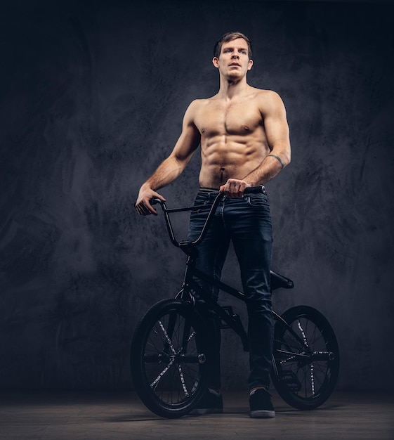 A handsome man with BMX in a studio.