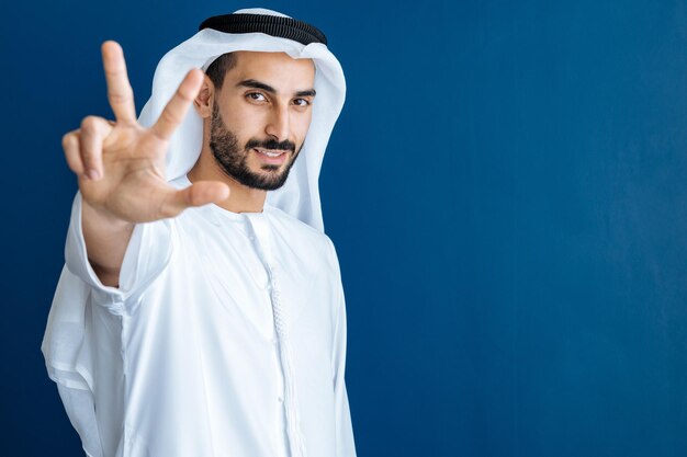 Handsome man with dish dasha working in his business office of Dubai