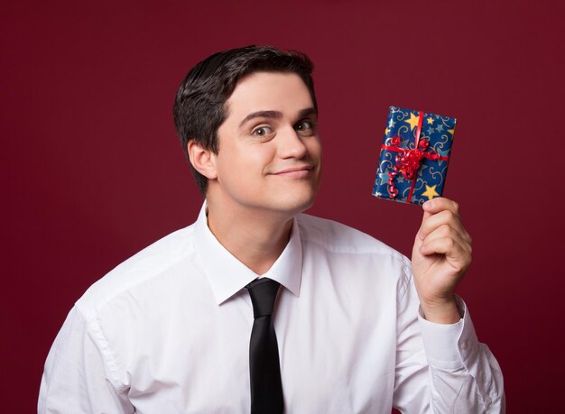 Handsome man with gift. Studio shot.