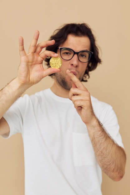 Handsome man with glasses gold bitcoin in hands isolated background