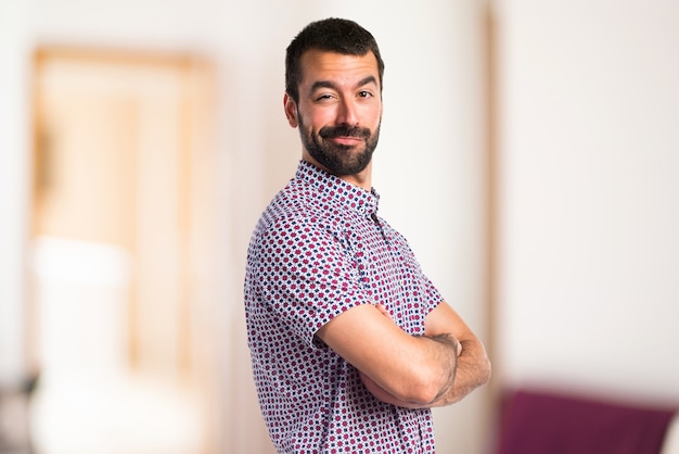 Handsome man with his arms crossed on unfocused background