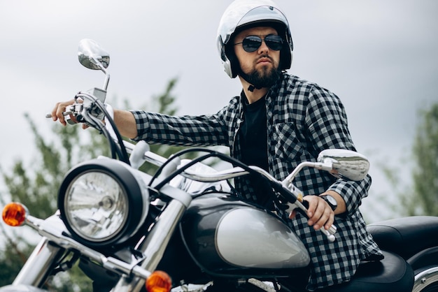 Handsome man with his moto in sand quarry