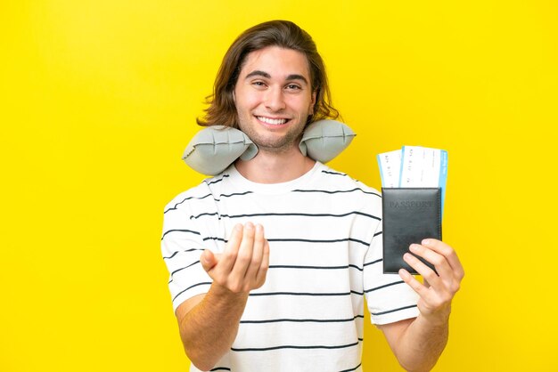 Handsome man with inflatable travel pillow inviting to come with hand happy that you came