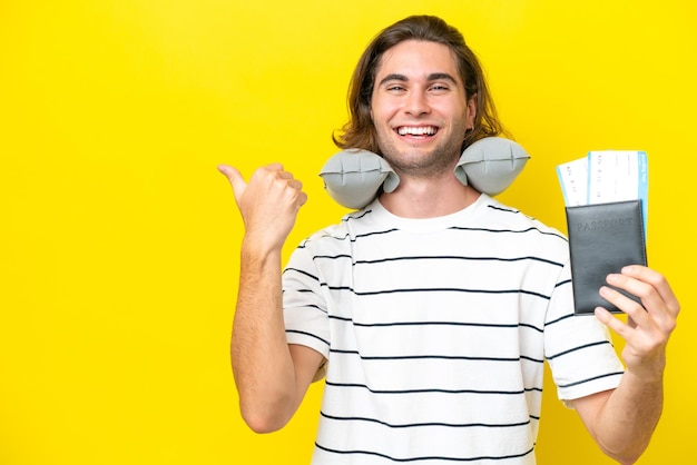 Handsome man with inflatable travel pillow pointing to the side to present a product