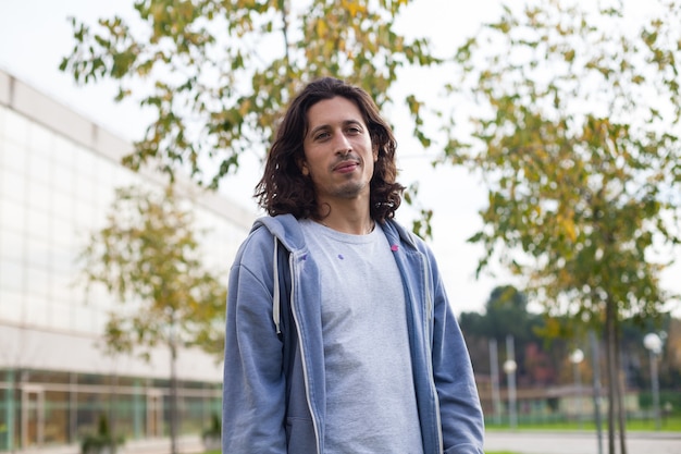 Foto bell'uomo con i capelli lunghi in un maglione